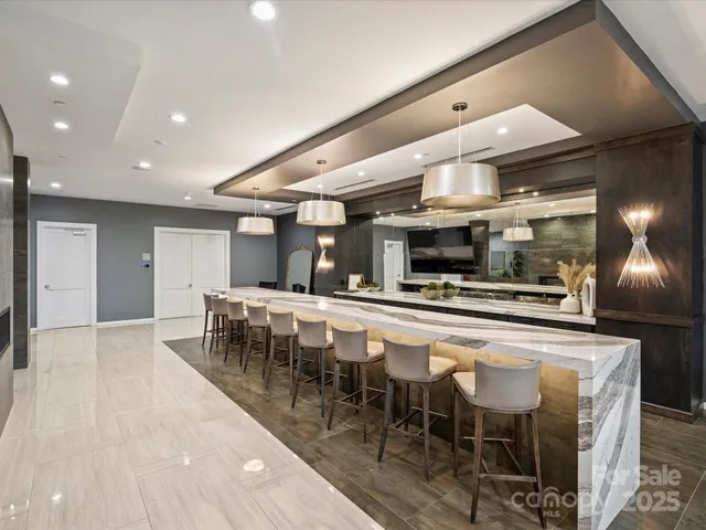 a living room with furniture a flat screen tv and kitchen view