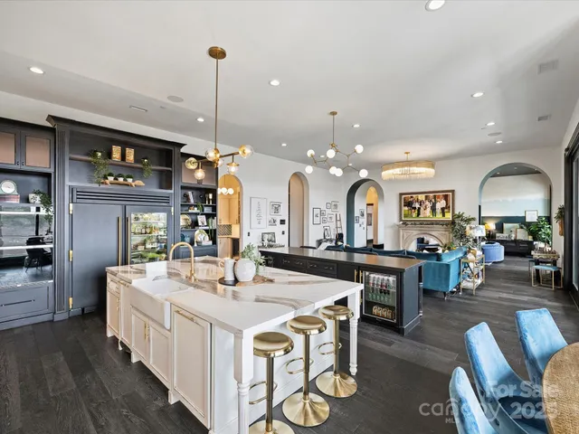a large kitchen with a counter space a sink appliances and dining table