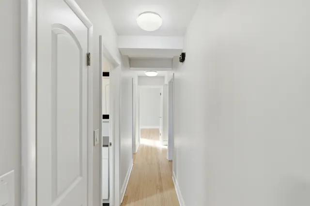 a view of a hallway with wooden floor