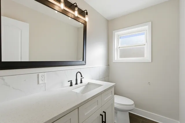 a bathroom with a sink a toilet and a mirror