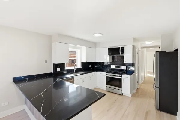 a kitchen with stainless steel appliances granite countertop a stove a sink and a refrigerator