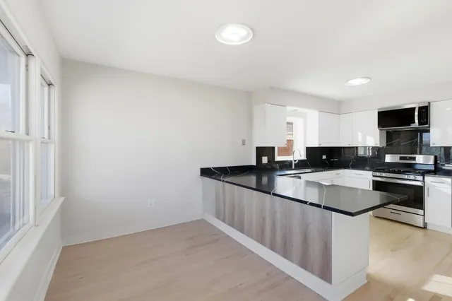 a kitchen with granite countertop a sink and a stove top oven