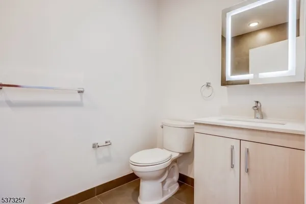 a bathroom with a toilet a sink and mirror