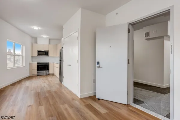 a view of a kitchen with a refrigerator and a stove top oven