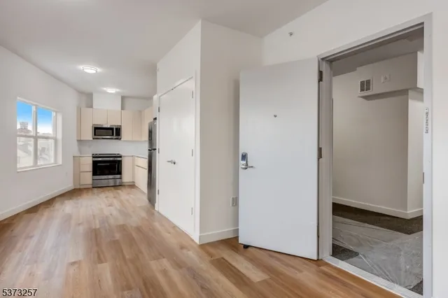 a view of a kitchen with a refrigerator and a stove top oven