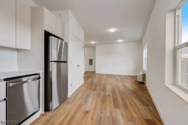 a view of empty room with wooden floor