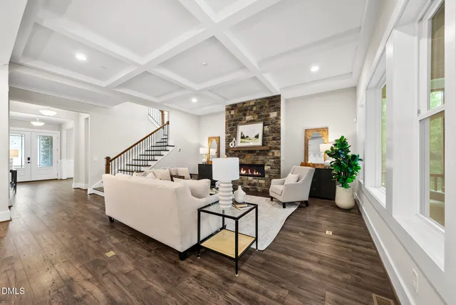 a living room with fireplace furniture and a large window