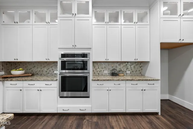 a large kitchen with granite countertop a large counter top a sink stainless steel appliances and cabinets