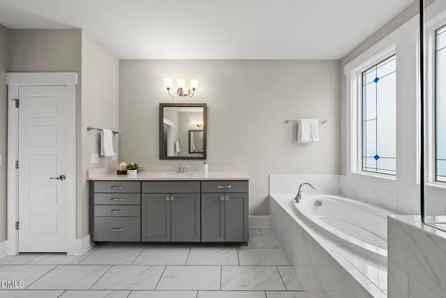 a spacious bathroom with a granite countertop sink mirror and shower