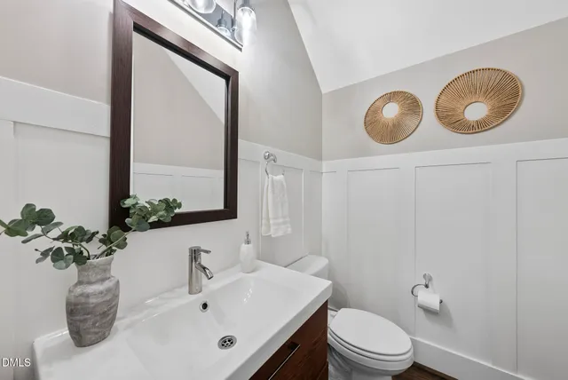 a bathroom with a granite countertop sink toilet a mirror and shower