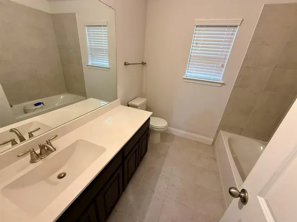 a spacious bathroom with a double vanity sink and a tub