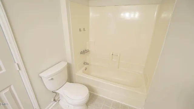 a white toilet sitting next to a bath tub