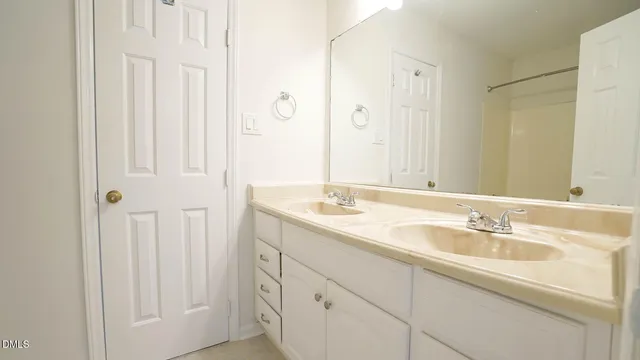 a bathroom with double sink and a mirror
