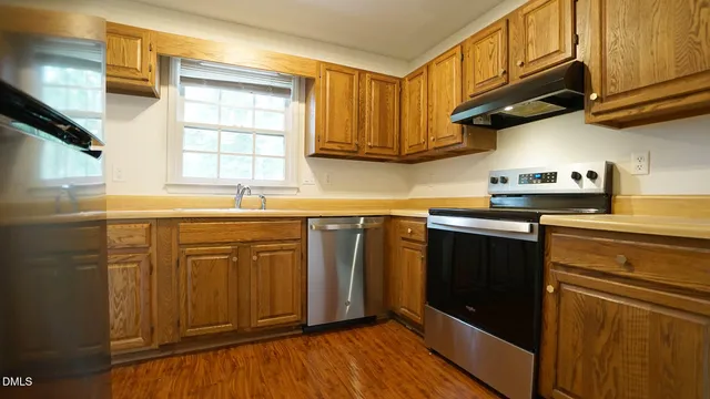 a kitchen with stainless steel appliances granite countertop a sink a stove a microwave and cabinets