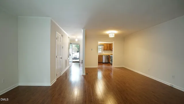 a view of empty room with wooden floor