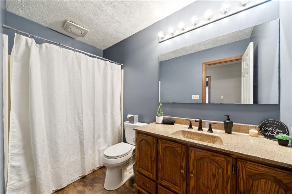 116 Buttercup School Road Renfrew, PA 16053 - Photo 24 of 34 a bathroom with a granite countertop sink a toilet and a mirror