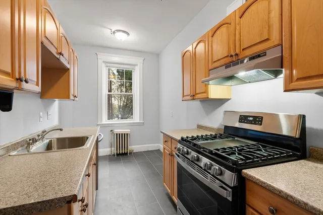 a kitchen with granite countertop a stove and a sink