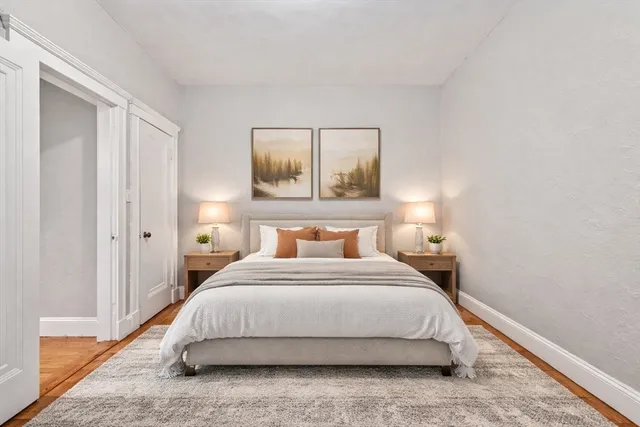 a bedroom with a bed and painting on the wall