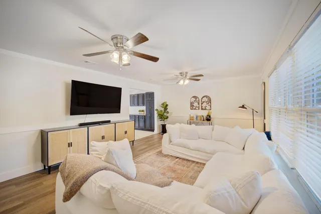 a view of a room with wooden floor and a ceiling fan