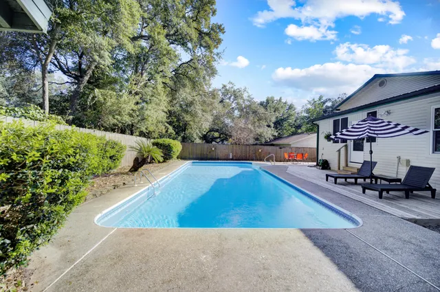 a view of a swimming pool with a patio and a garden