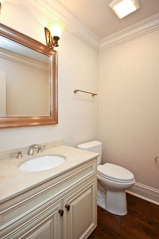 1035 Willow Road Winnetka, IL 60093 - Photo 15 of 25 a bathroom with a sink a toilet and a mirror
