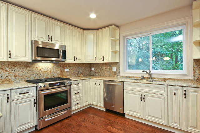 1035 Willow Road Winnetka, IL 60093 - Photo 3 of 25 a kitchen with granite countertop white cabinets a sink and a oven with wooden floor