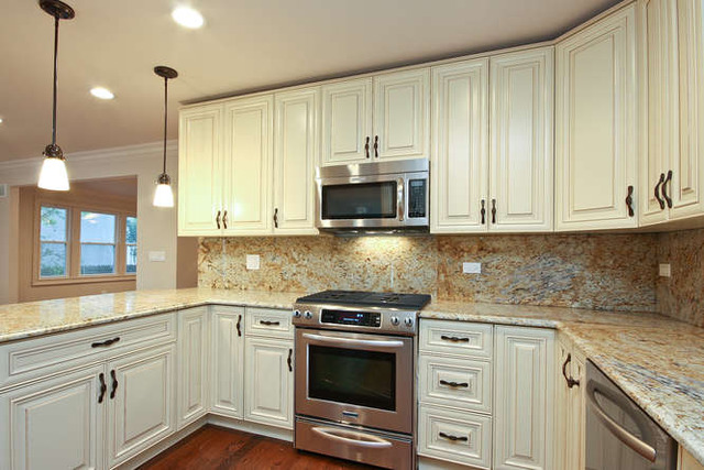 1035 Willow Road Winnetka, IL 60093 - Photo 4 of 25 a kitchen with granite countertop white cabinets and stainless steel appliances