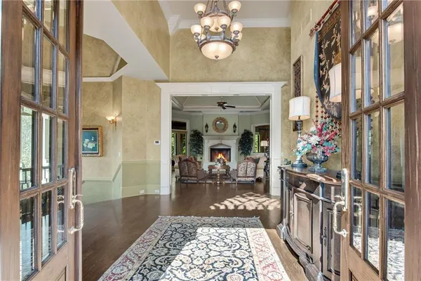 a view of a hallway to a chandelier and dining room