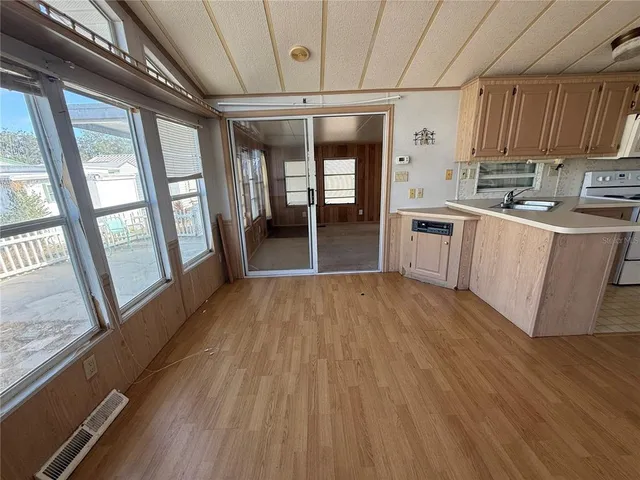 a open kitchen with cabinets and wooden floor