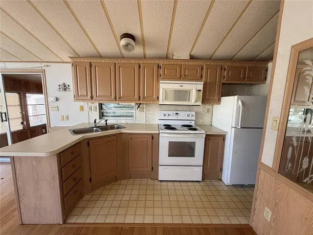 a kitchen with a sink a refrigerator and cabinets