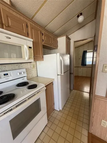 a kitchen with a stove top oven and refrigerator