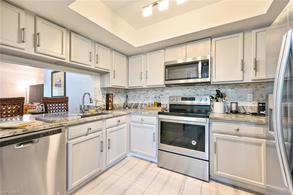 a kitchen with cabinets stainless steel appliances a sink and a stove