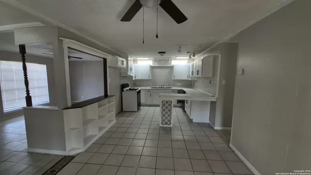 a kitchen with stainless steel appliances kitchen island granite countertop a sink and a refrigerator