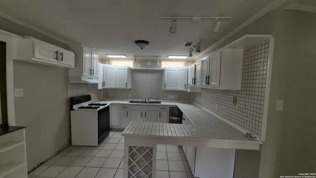 a kitchen with granite countertop a sink and a stove top oven