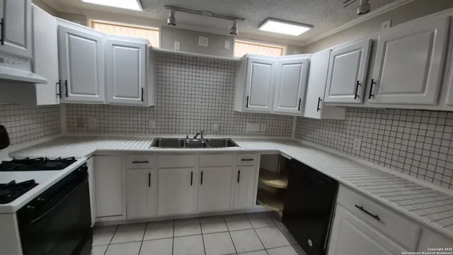 a kitchen with a sink stove and cabinets