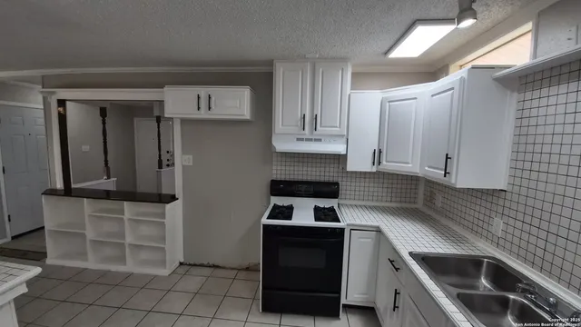 a kitchen with granite countertop white cabinets and stainless steel appliances