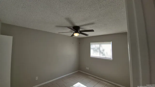 an empty room with closet and a chandelier fan