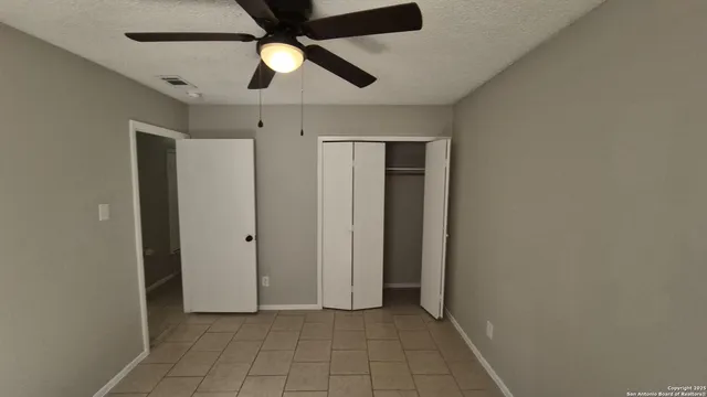 an empty room with a window and a fan