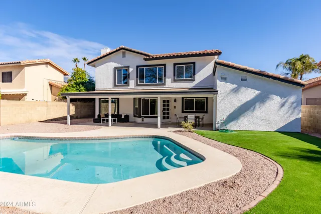 a view of house with swimming pool outdoor seating
