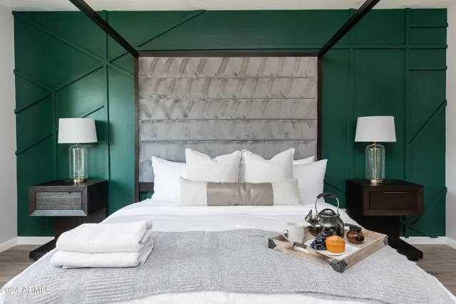 a bedroom with a bed and a flat tv screen on dresser