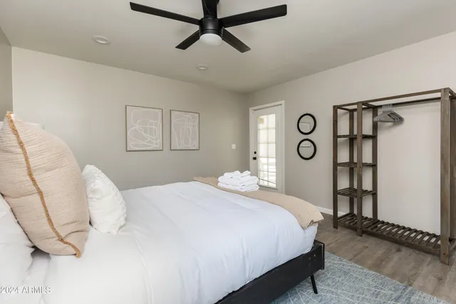 a bedroom with a bed a ceiling fan and a dresser
