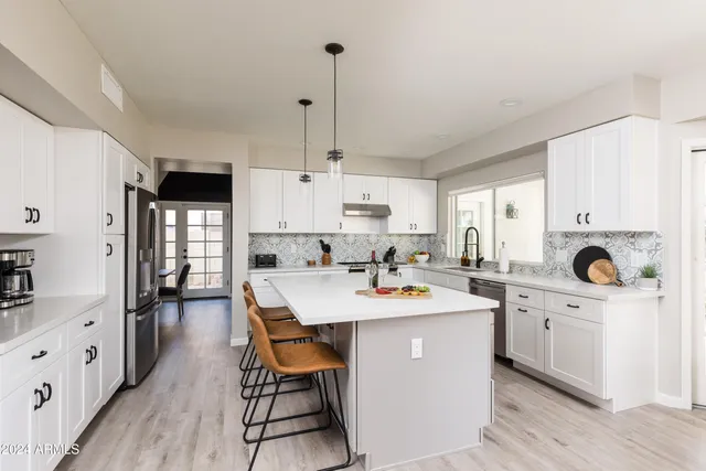 a kitchen with a refrigerator a stove top oven a sink dishwasher and wooden cabinets with wooden floor