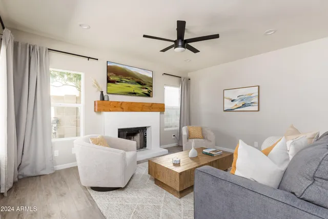 a living room with furniture a fireplace and a large window