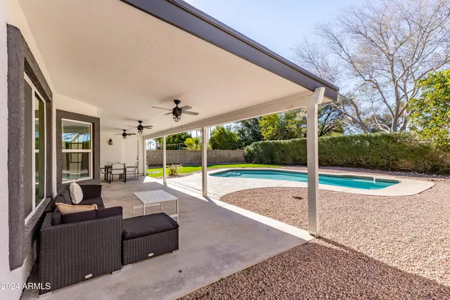 a view of a swimming pool with a table and chairs under an umbrella