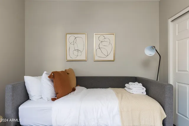 a bedroom with a bed and painting on the wall