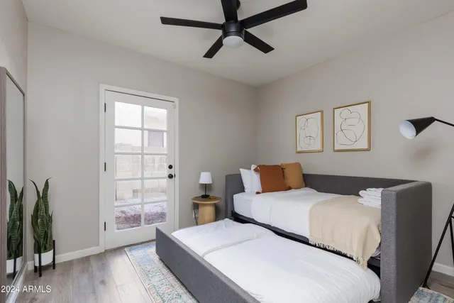 a bedroom with a large bed and a potted plant