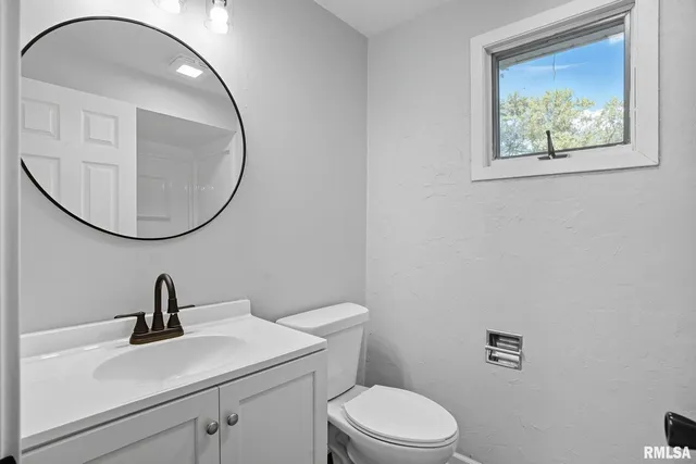 a bathroom with a toilet a sink and mirror