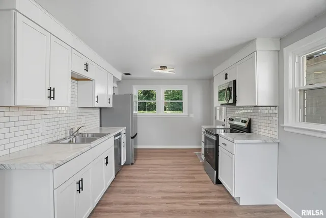 a kitchen with stainless steel appliances granite countertop a sink stove and cabinets
