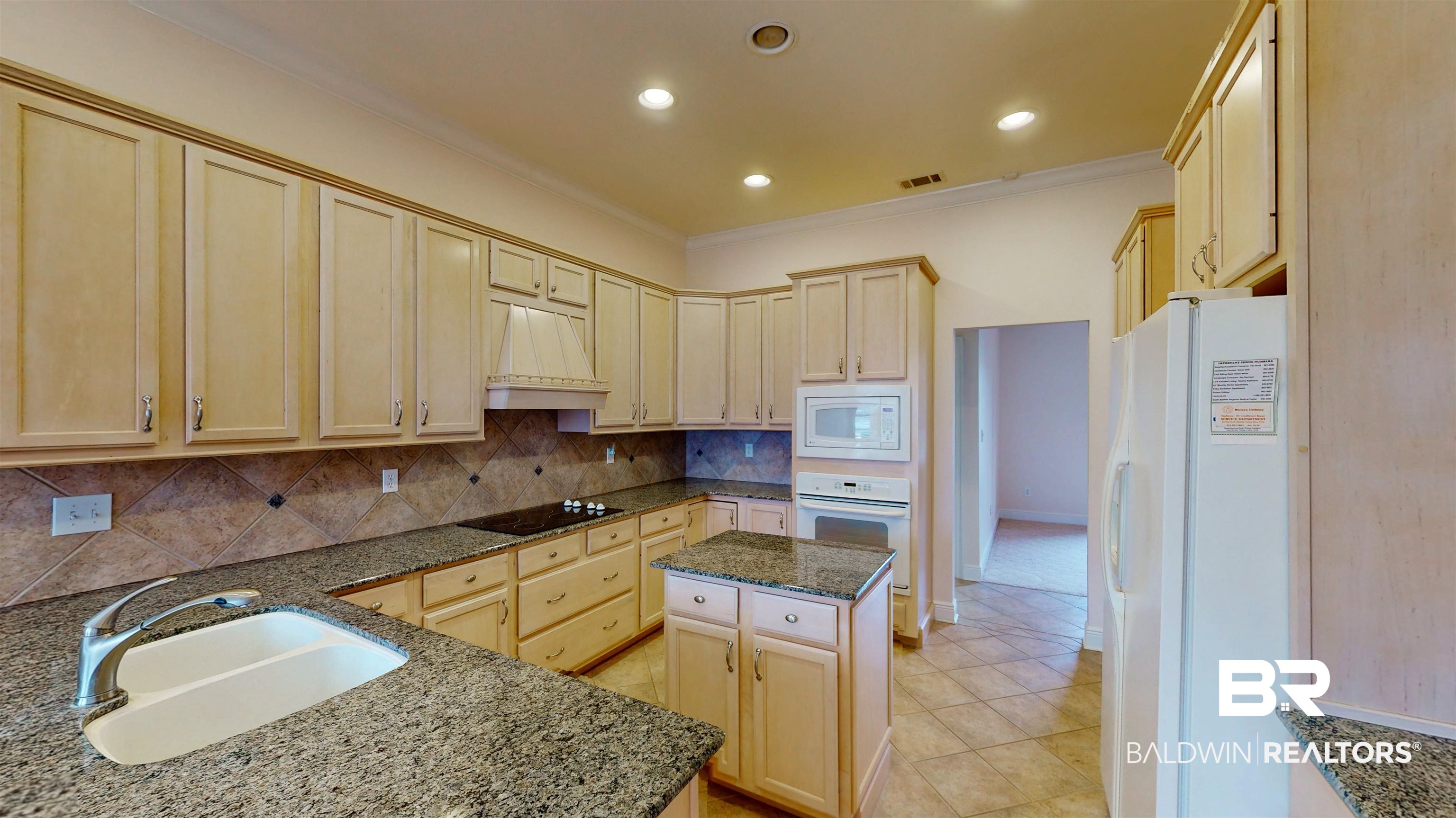 214 Hemingway Loop Foley, AL 36535 - Photo 12 of 67 Kitchen with white appliances, dark stone counters, backsplash, light brown cabinetry, and custom range hood