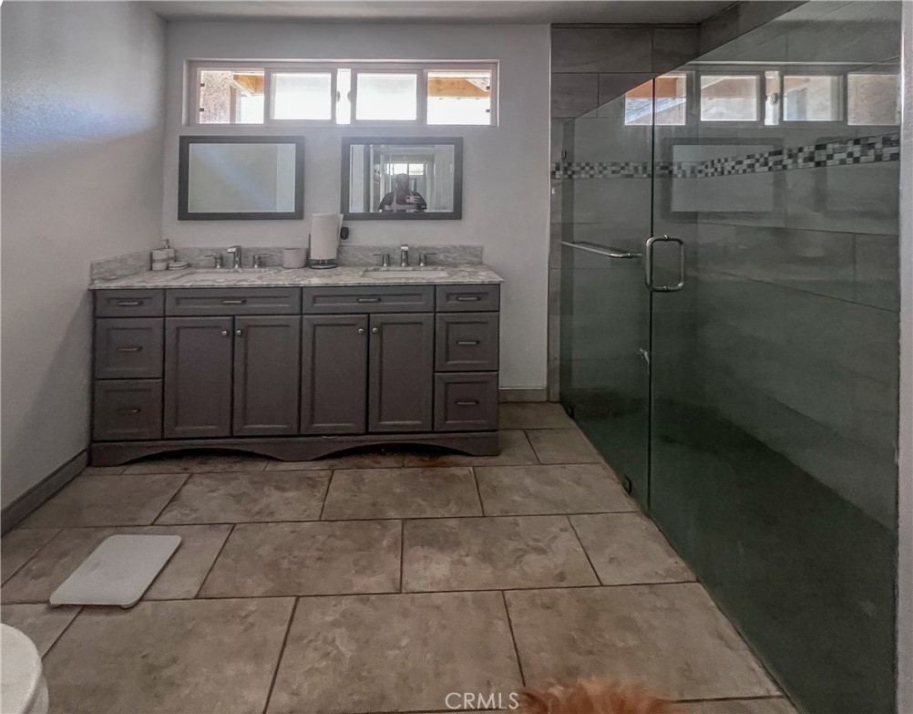4301 Arlington Avenue Los Angeles, CA 90008 - Photo 12 of 18 a bathroom with a granite countertop sink a mirror and a shower